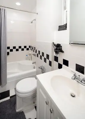 a white bathroom with a toilet and a sink at Cozy 1BD Upper East Side Gem in New York