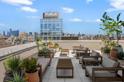 a rooftop patio with couches and tables and a building at Freeman 602 by Rove Travel - Condo with Shared Amenities in New York