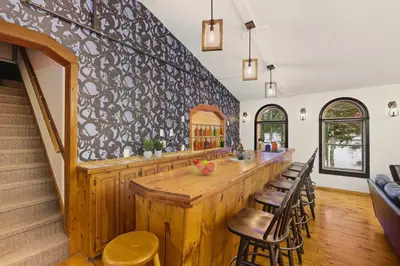 a kitchen with a large wooden bar with chairs at The Mahogany Villa Indoor pool Spa Sauna Gameroom in Dover