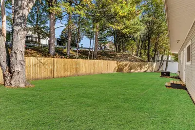 a yard with a fence and a tree at The Main Lineup 2 - All Star Baseball Rentals in Oneonta