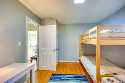 a bedroom with two bunk beds and a hallway at Riverfront Apt with Fire Pit and Yard in Millers Falls