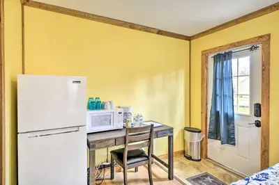 a kitchen with a table with a microwave and a refrigerator at Log Cabin and Suite Close to Ski Adventures in Pleasant Mount