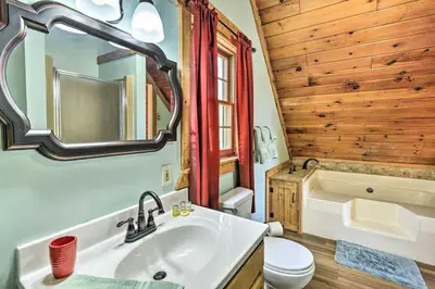 a bathroom with a sink and a toilet and a tub at Log Cabin and Suite Close to Ski Adventures in Pleasant Mount
