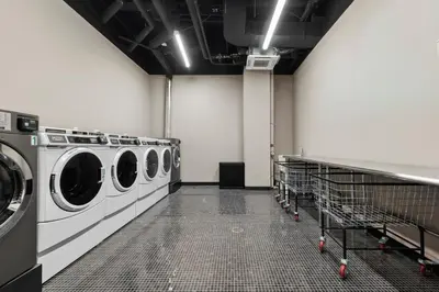 a laundry room with three washing machines in it at Freeman 401 by Rove Travel - Studio w Shared Amenities in New York