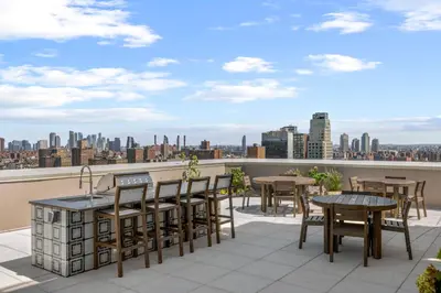 a balcony with tables and chairs and a view of the city at Freeman 701 by Rove Travel - Studio with Shared Amenities in New York