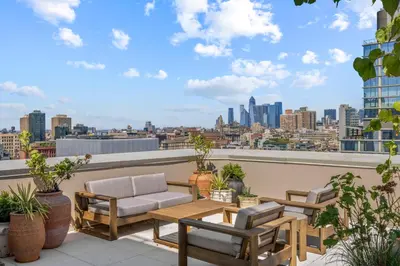 a patio with a table and chairs on a roof at Freeman 403 by Rove Travel - 1BR Condo with Shared Amenities in New York