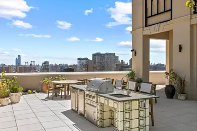an outdoor kitchen on a patio with a view of the city at Freeman 503 by Rove Travel - 1BR Condo with Shared Amenities in New York