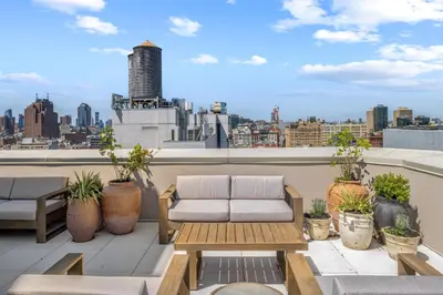 a balcony with a couch and a view of a city at Freeman 803 by Rove Travel - 1BR Condo with Shared Amenities in New York
