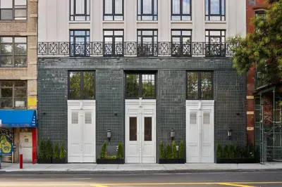 a brick building with white doors on a street at Freeman 803 by Rove Travel - 1BR Condo with Shared Amenities in New York