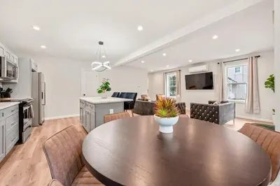 a kitchen and living room with a wooden table and chairs at Luxury 5BR Home in Central Bloomfield Spot in Bloomfield