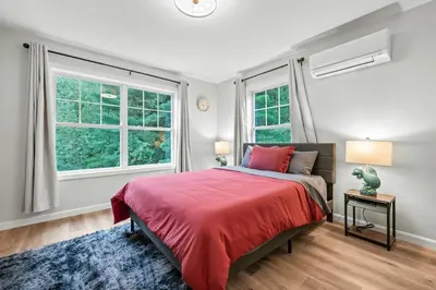 a bedroom with a red bed and two windows at Luxury 5BR Home in Central Bloomfield Spot in Bloomfield