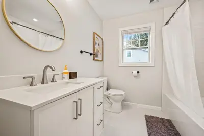 a bathroom with a sink and a toilet and a mirror at Spacious House with King Beds in Prime Location in Bloomfield