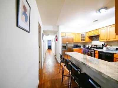 a kitchen with wooden cabinets and a counter top at Charming Private Room in a Friendly Home mins to NYC in Jersey City