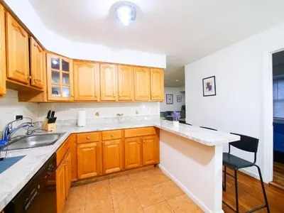 a kitchen with wooden cabinets and a sink at Charming Room with Shared Space close to NYC in Jersey City