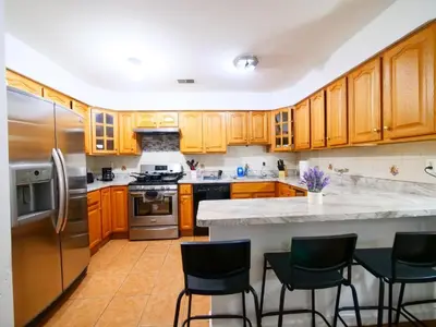 a kitchen with wooden cabinets and stainless steel appliances at Charming Room with Shared Space close to NYC in Jersey City