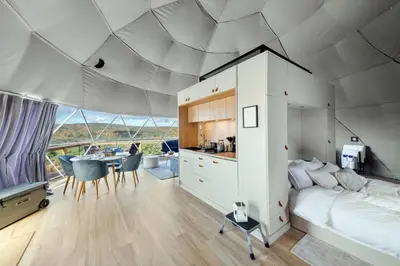 a bedroom with a bed and a kitchen with a table at Barrel Hot Tub at 'The Eagle Dome' in Franklin in Franklin