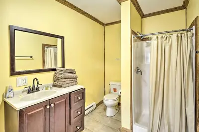 a bathroom with a sink and a toilet and a mirror at Cottages and Suites near Ski Slopes in Pleasant Mount
