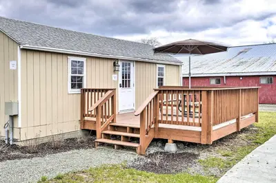 a house with a large deck with an umbrella at Cottages and Suites near Ski Slopes in Pleasant Mount