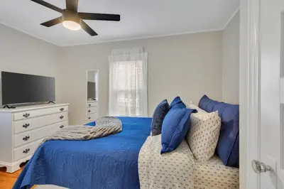 a bedroom with a blue bed and a tv at The Game House Arcade West Hartford in West Hartford