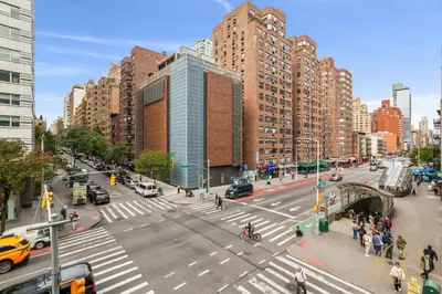 a busy city street with cars and pedestrians and buildings at Beautiful 1-Bedroom in the Upper East Side in New York