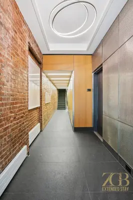 a hallway with a brick wall and a ceiling at Fully Furnished PH Duplex with Private Outdoor Space in New York