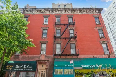 a red brick building on a city street at Sweet and Cozy 1 Bedroom Apt in Lenox Hill in New York