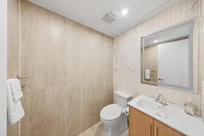 a bathroom with a toilet and a sink and a mirror at The Cosmo Outstand NYC - Private Room near Times Square in New York
