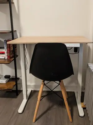 a black chair sitting at a wooden desk at The Bellagio NYC in New York