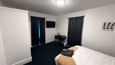 a hotel room with a bed and a television at Nona - Private Room 1 with Parking, Desk & Fast WiFi near Yale, Quinnipiac, SCSU & Hospitals in Hamden