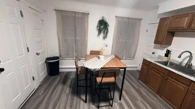 a kitchen with a table and chairs and a sink at Nona - Private Room 1 with Parking, Desk & Fast WiFi near Yale, Quinnipiac, SCSU & Hospitals in Hamden