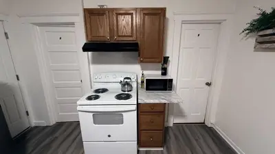 a kitchen with a white stove and wooden cabinets at Nona - Private Room 2 with Parking, Desk & Fast WiFi near Yale, Quinnipiac, SCSU & Hospitals in Hamden
