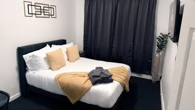 a bedroom with a bed with white sheets and pillows at Nona - Private Room 3 with Parking, Desk & Fast WiFi near Yale, Quinnipiac, SCSU & Hospitals in Hamden