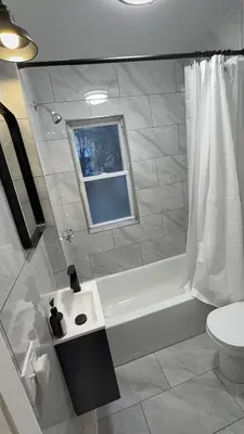 a bathroom with a tub and a toilet and a window at Nona - Private Room 3 with Parking, Desk & Fast WiFi near Yale, Quinnipiac, SCSU & Hospitals in Hamden