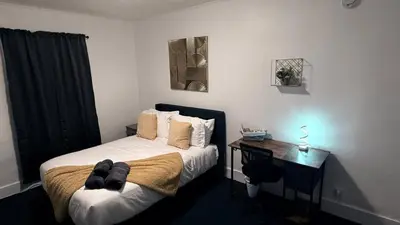 a small bedroom with a bed and a desk at Nona - Cozy 3BR Apt with Parking, Desk & Fast WiFi near Yale, Quinnipiac, SCSU & Hospitals in Hamden