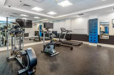 a gym with several treadmills and cardio machines at Chic Studio Retreat in New Haven in New Haven