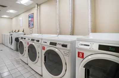 a laundry room with a row of washing machines at Modern 1BR perfect for extended visits in New Haven