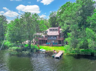 a house on a river with a dock in the water at Lakefront Big Bass Lake Dock Games in Gouldsboro