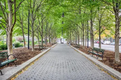 a walkway with benches and trees in a park at Blueground Financial District rooftop nr Brooklyn Bridge NYC-2201 in New York