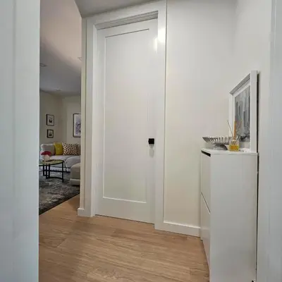 a hallway with a white door in a living room at Bright Modern 2-bedroom apartment - Prime Astorioa - near subway in Woodside
