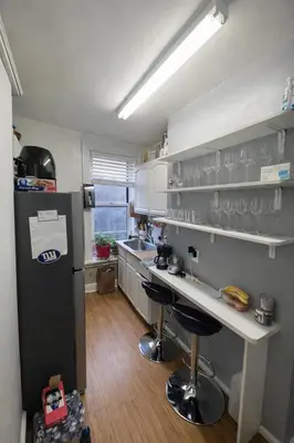 a kitchen with a refrigerator and a counter with bar stools at Room in a 2 Bedrooms Apartament Long Island City, Kitchen and Bathroom shared with very nice host in New York