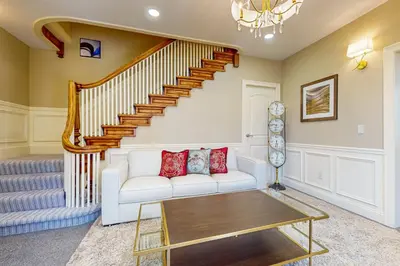 a living room with a white couch and stairs at Centrally Located Home by Holyoke Medical Center in Holyoke