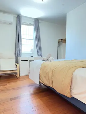a bedroom with a bed and a desk and a window at New York Flushing private room in Flushing