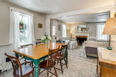 a living room with a wooden table and chairs at Historic 1820s Homestead on Battenkill River! in Arlington