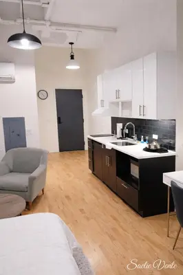 a kitchen with a sink and a couch in a room at Pratt St Brand New Studio Loft Elevator Building in Hartford