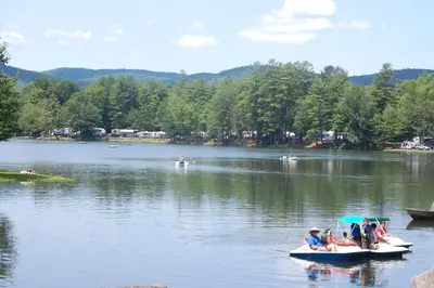 a group of people in boats on a lake at Alpine Lake Lakefront Park Model 4 in South Corinth