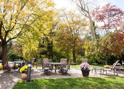 a patio with tables and chairs in a park at Hampton Inn Albany-Western Ave/University Area, NY in Albany