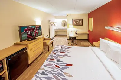 a hotel room with a bed and a flat screen tv at Red Roof Inn Milford - New Haven in Milford