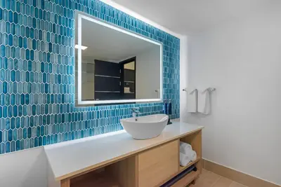a bathroom with a sink and a mirror at Blue - A Modern Hotel, an Ascend Collection Hotel in West Springfield