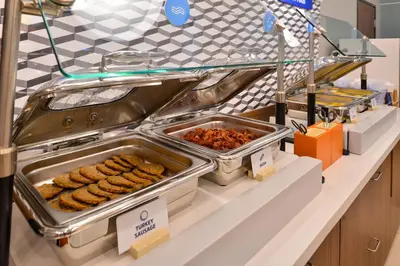 a buffet line with trays of food on a counter at Holiday Inn Express Vernon-Manchester by IHG in Vernon