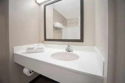 a white bathroom with a sink and a mirror at Extended Stay America Suites - White Plains - Elmsford in Elmsford